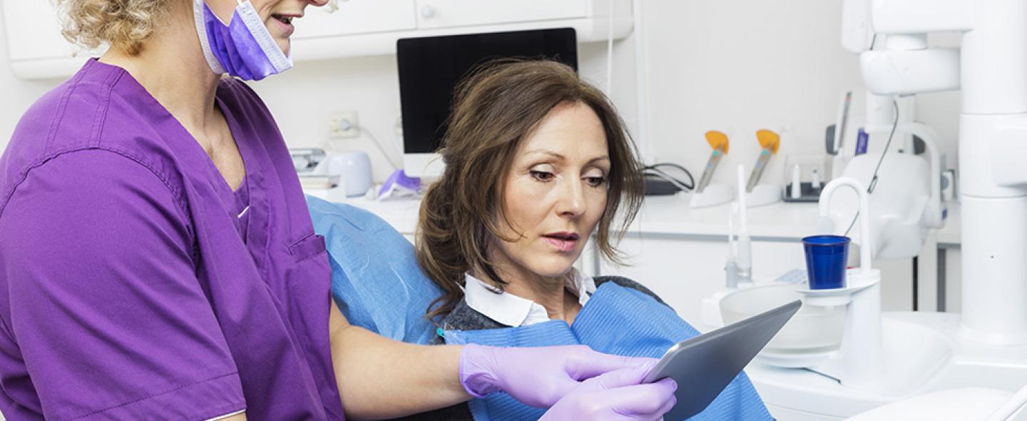 hammaslääkäri antaa vastaanotolla potilaalle ohjeita omahoitoon