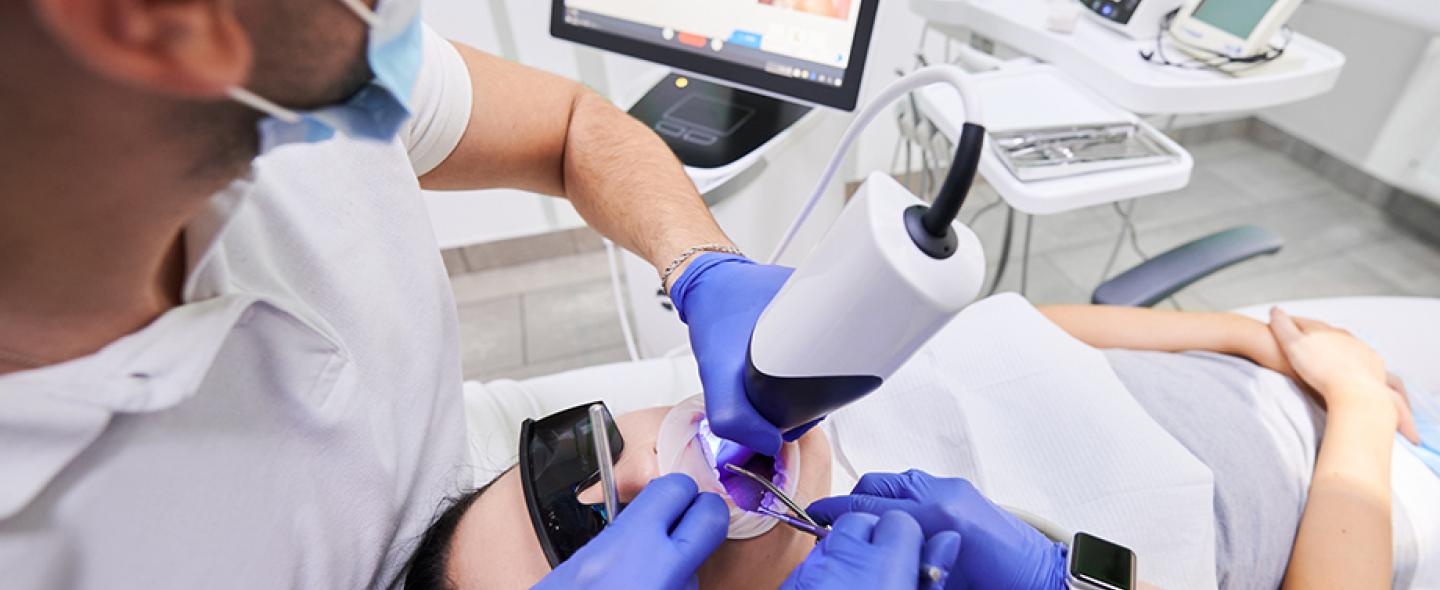 Hammaslääkäri tutkii potilasta suuskannerilla