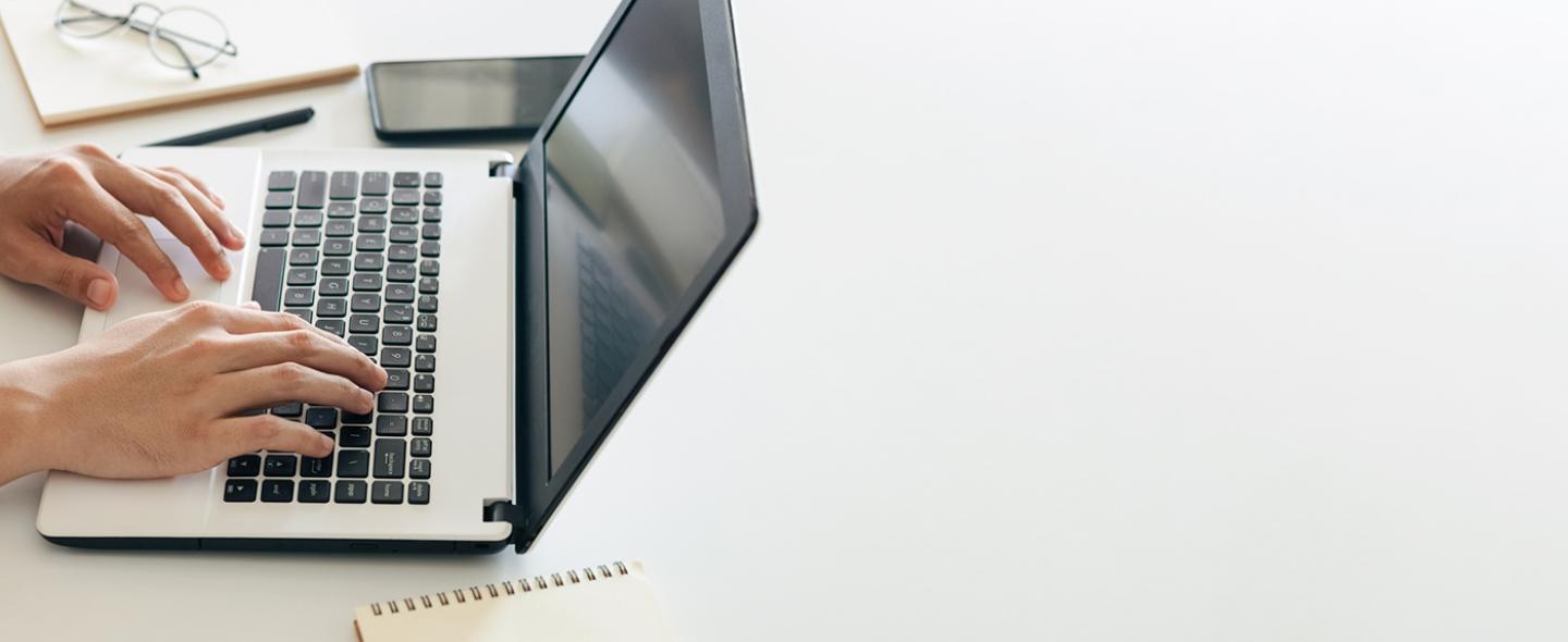 Käyttäjä työskentelee kannettavan tietokkoneen ääressä