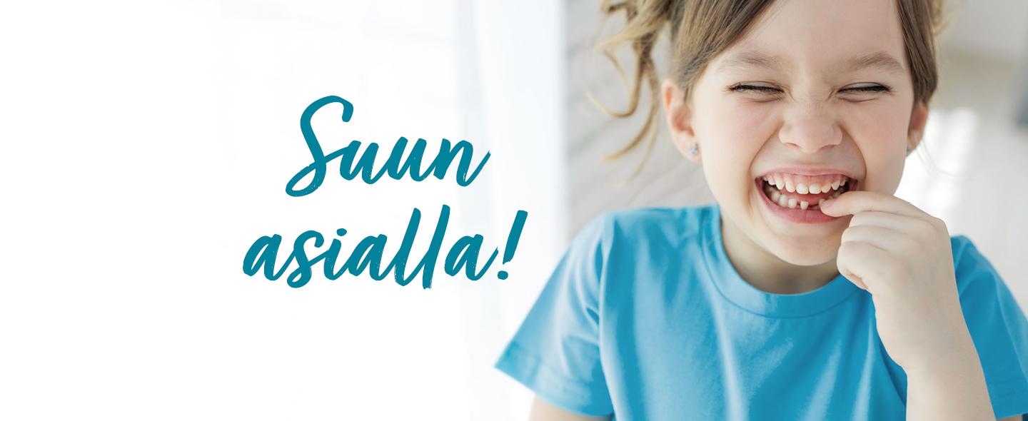 Naurava lapsi osoittaa suussaan olevaa maitohammasta