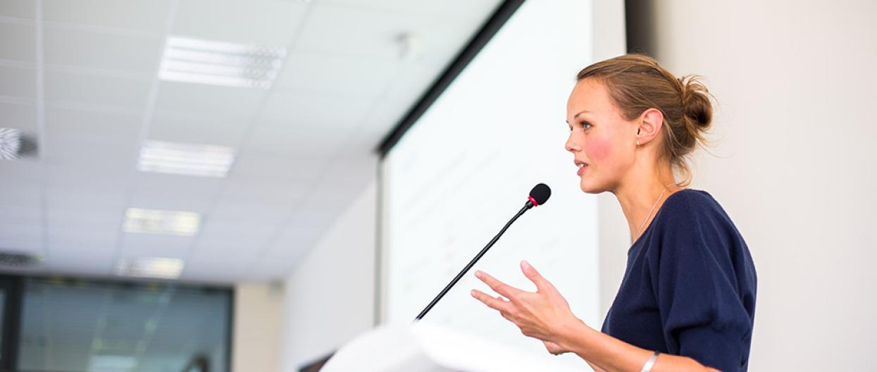 Luennoitsija puhuu auditoriossa