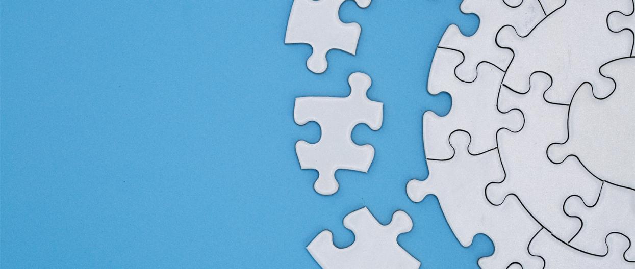 Valkoisia palapelin palasia sinisellä taustalla