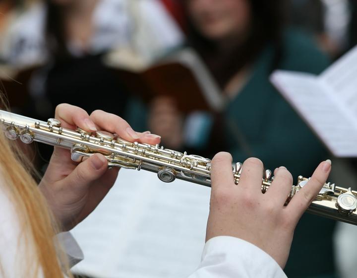 Naismuusikko soittaa huilua sinfoniaorkesterissa